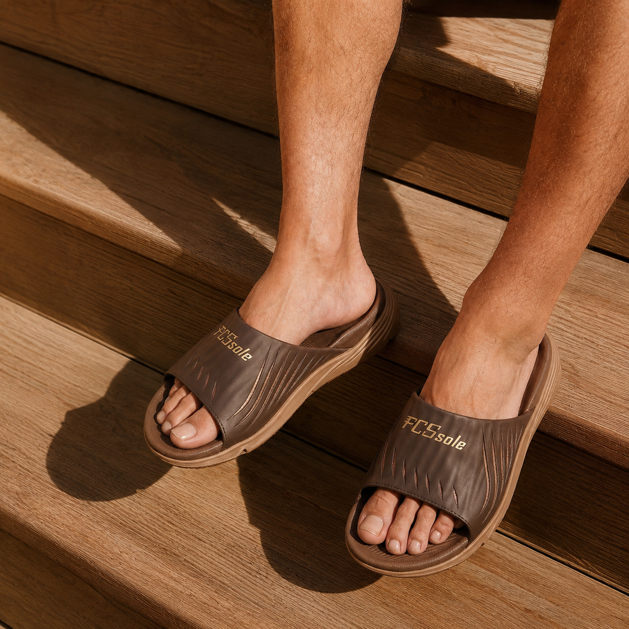Brown sandals with 'PCSsole' branding on a wooden floor.