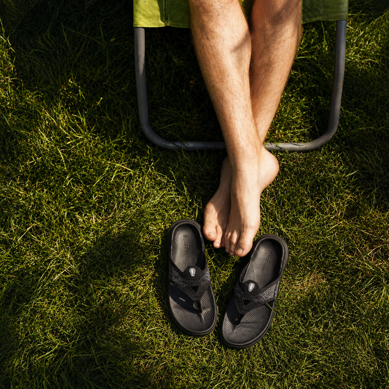 Person wearing black sandals on grass